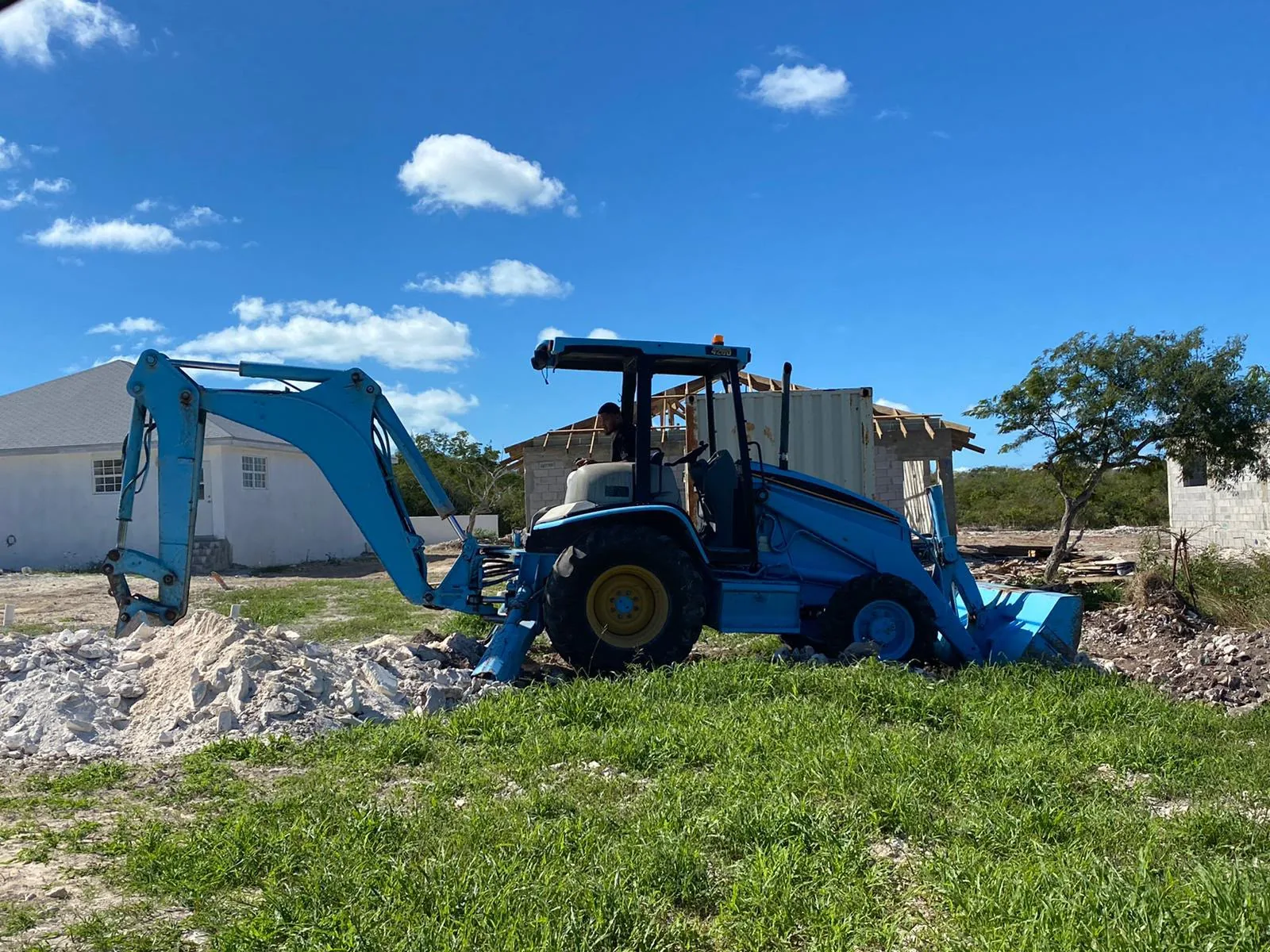 Backhoe loader at a cleared project site