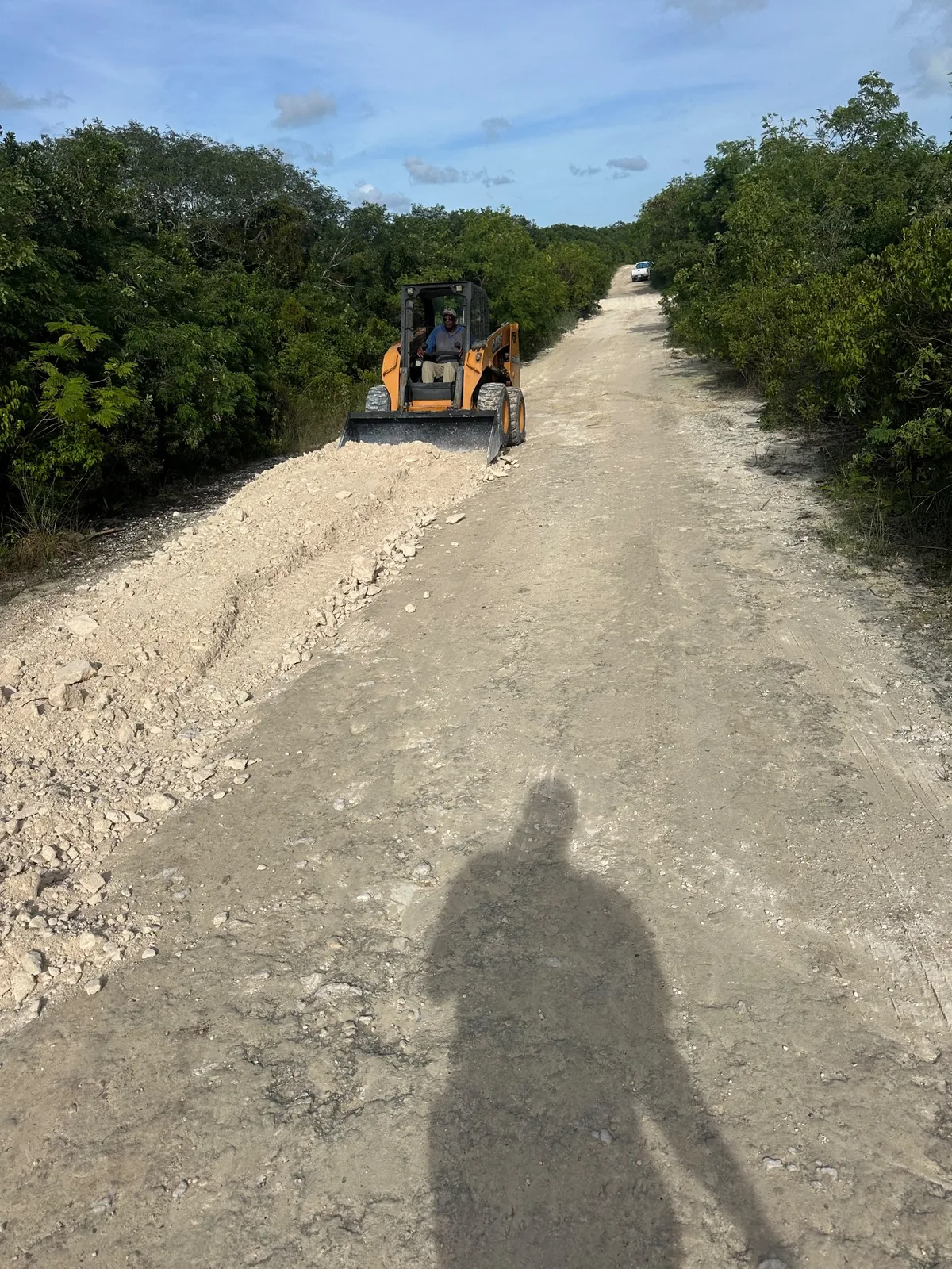 Skid steer grading an unpaved road